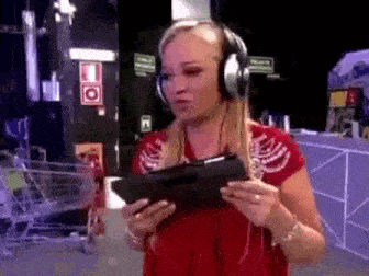 a woman wearing headphones is holding a tablet in her hand .