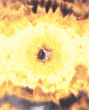 a close up of a person 's eye in a circle of flames