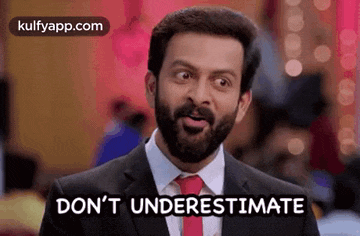 a man with a beard is wearing a suit and tie and says `` don 't underestimate '' .