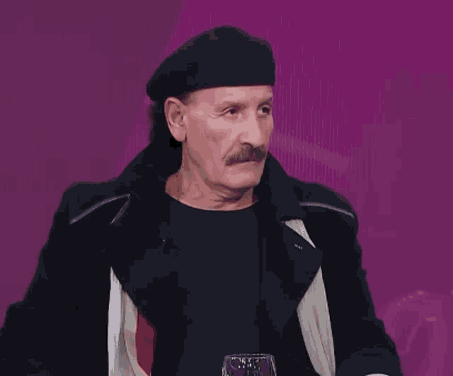 a man with a mustache is wearing a black beret and a black jacket