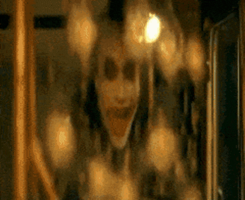 a blurry picture of a person with a scary face behind a glass door .
