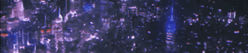 a blurry picture of a city skyline at night with purple and blue lights .