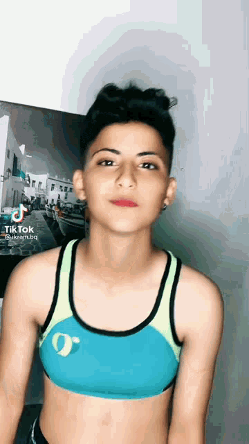 a young girl wearing a blue and green sports bra