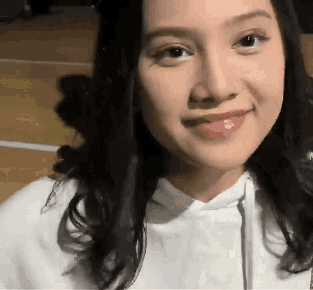 a close up of a woman wearing a white hoodie and red lipstick
