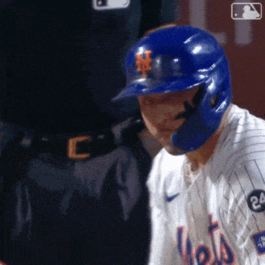 a mets baseball player is wearing a blue helmet and gloves