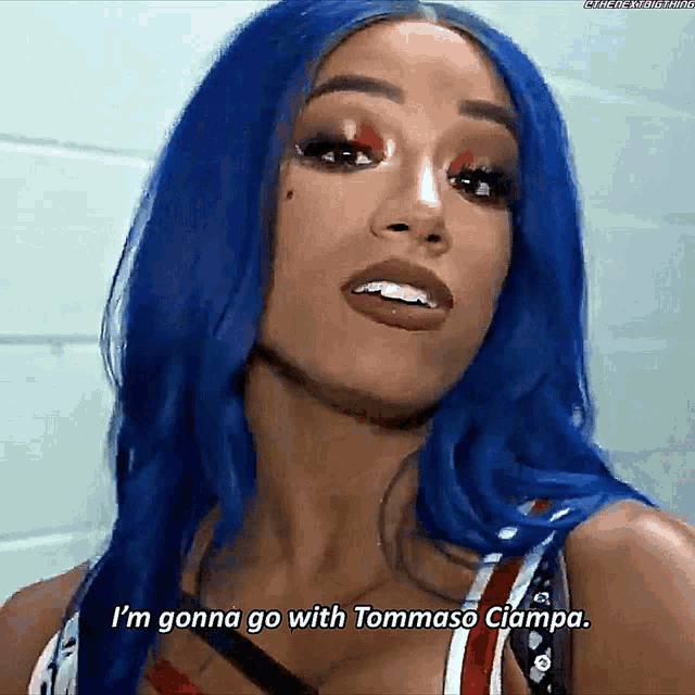 a woman with blue hair is smiling and says i 'm gonna go with tommaso ciampa