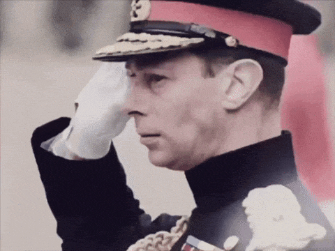 a man in a red and black uniform salutes