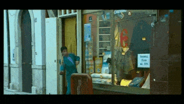 a man walking into a store with a sign that says domeni