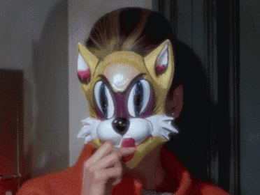 a woman wearing a cat mask with a red nose