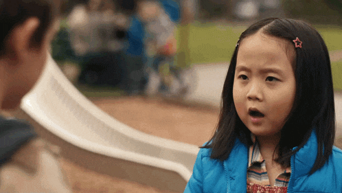 a little girl with a star in her hair is making a surprised face