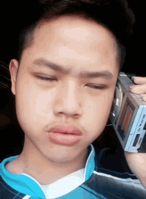 a young man is talking on a walkman that says ' tivoli ' on it