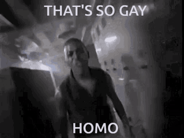 a man is walking in a dark room with the words `` that 's so gay homo '' written on the bottom .