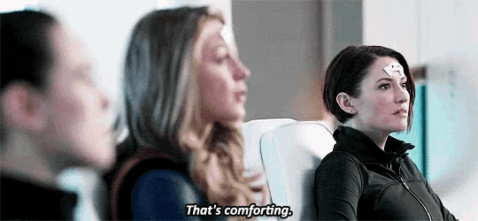 three women are sitting next to each other on a plane and one of them is talking .