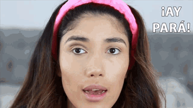 a woman wearing a pink headband says " i ay para " in spanish