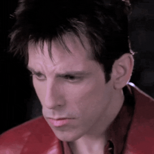 a close up of a man wearing a red jacket