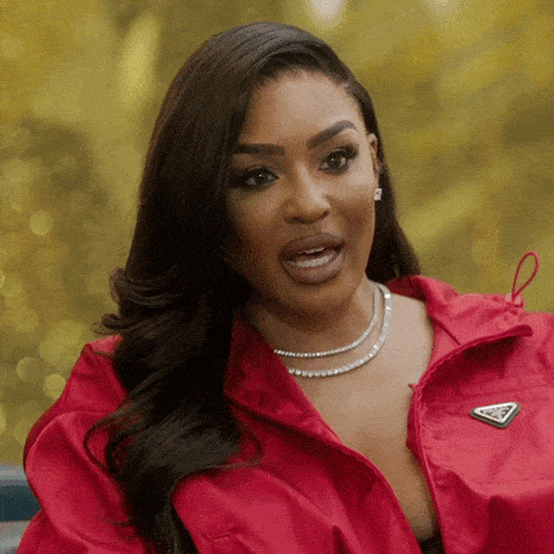 a woman wearing a red jacket with a triangle logo on the front