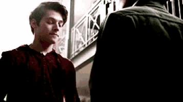 two young men are standing next to each other on a balcony .