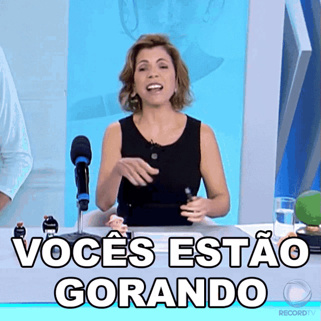 a woman sitting in front of a microphone with the words " vocês estão gorando "