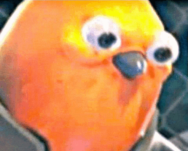 a close up of a yellow object with big eyes and a blue nose