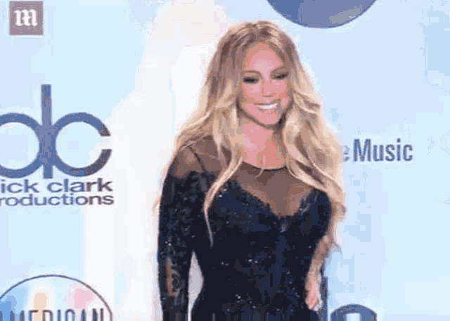 a woman in a black dress is standing in front of a sign that says dc music