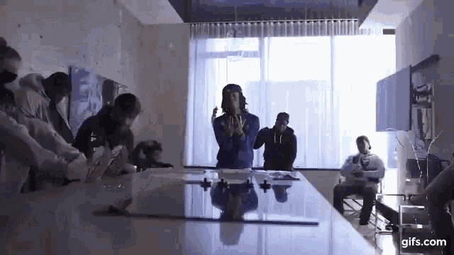 a group of people are standing around a table .