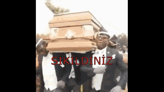 a man in a tuxedo is carrying a coffin with the words ' sikildiniz ' written on it