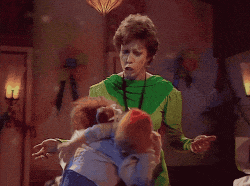 a woman in a green shirt holds a baby in her arms