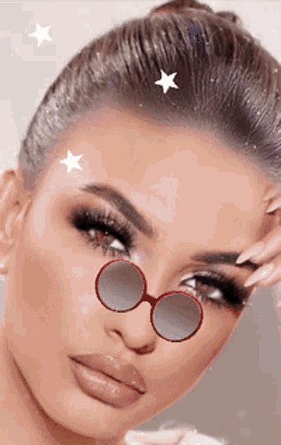 a close up of a woman wearing sunglasses with stars on her hair