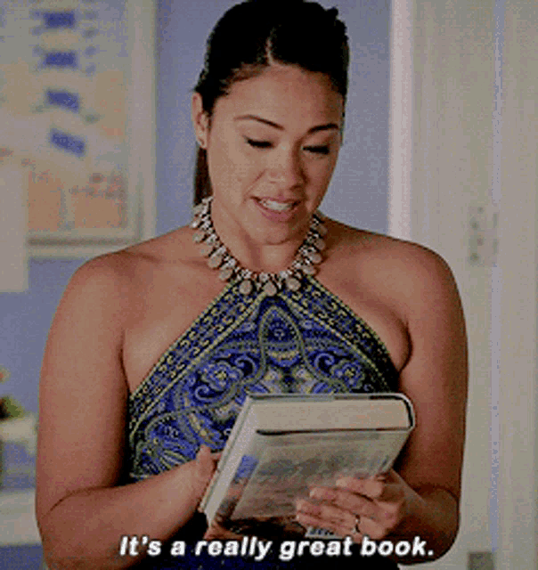 a woman holding a book with the words " it 's a really great book " below her