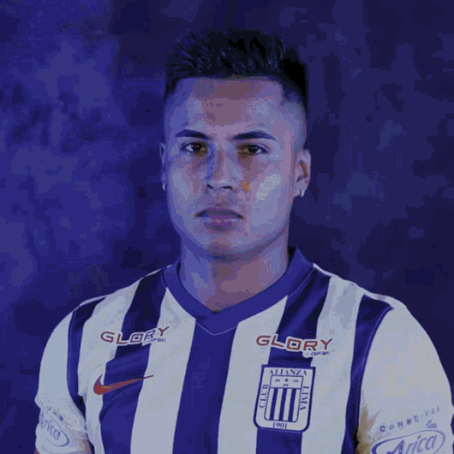 a man wearing a purple and white striped shirt with glory written on it