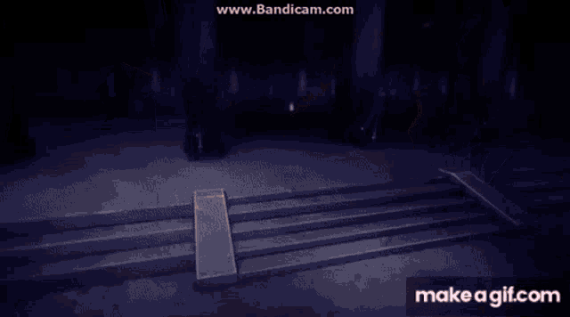 a person is holding a cross in a dark room with a light coming out of it .