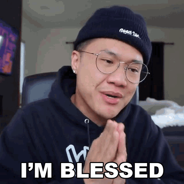 a man wearing glasses and a beanie is saying i 'm blessed