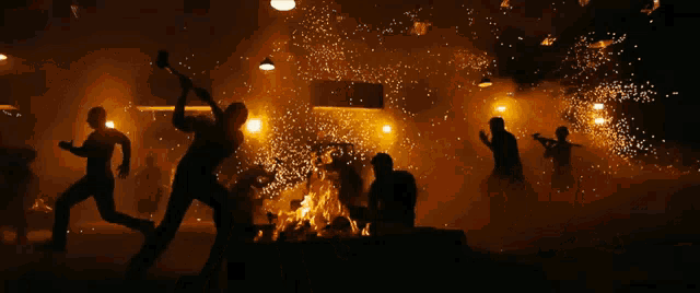 a group of people are standing around a fire with sparks coming out of it