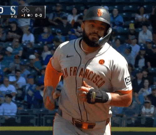 a baseball player wearing a san francisco uniform is running towards home plate