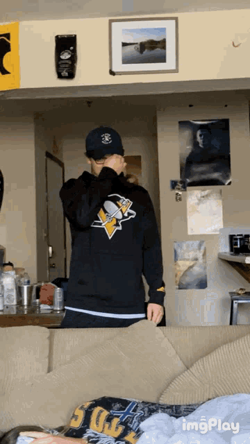 a man in a pittsburgh penguins shirt is covering his face