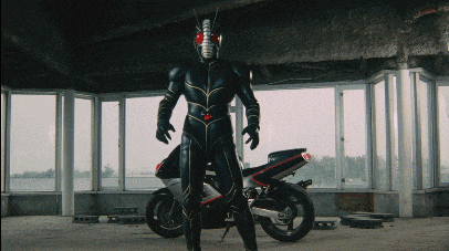 a man in a black suit is standing next to a black motorcycle