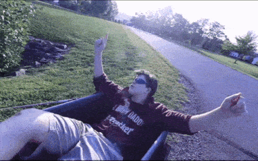 a man wearing a shirt that says daddy dado cracker is laying in a wheelbarrow
