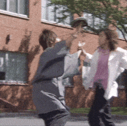 a woman in a pink shirt throws a hat at another woman in a white jacket