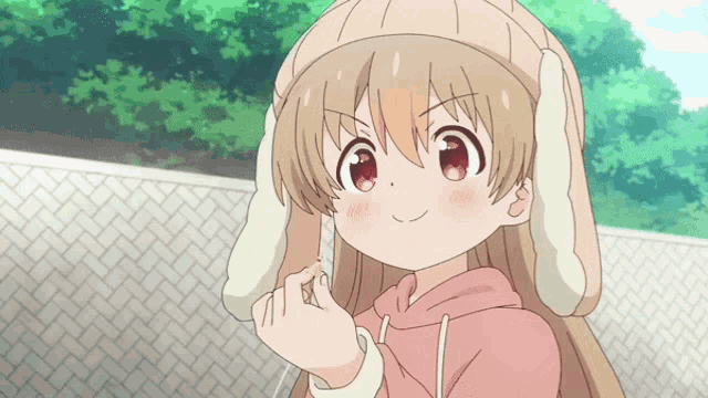a girl with bunny ears is wearing a pink hoodie and a beanie