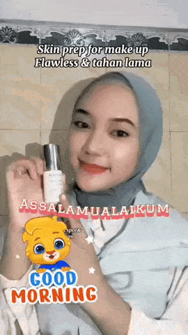 a woman in a hijab is holding a bottle of lotion in her hand .