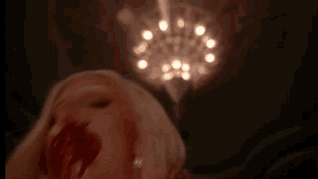 a woman with blood on her face is laying on a bed .