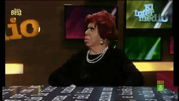 a woman sits at a table in front of a tv screen that says el inter medio