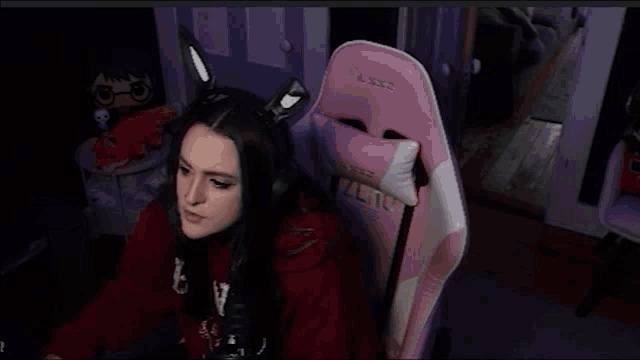 a girl in a red shirt is sitting in a pink chair with the word zero on it