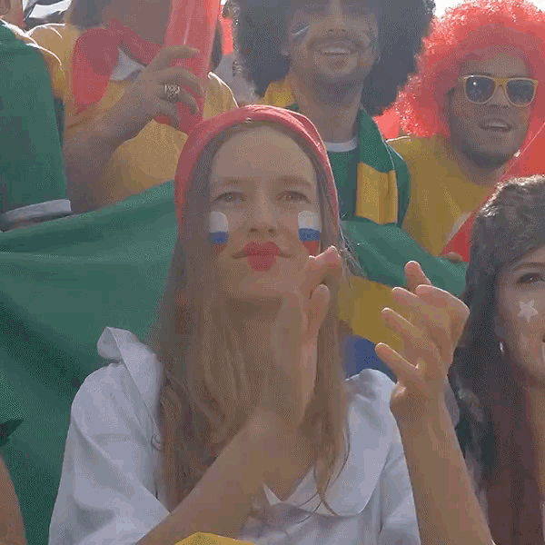 a woman with red white and blue paint on her face is making a funny face