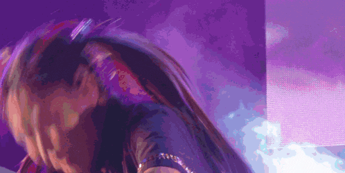 a close up of a woman 's face with a purple background