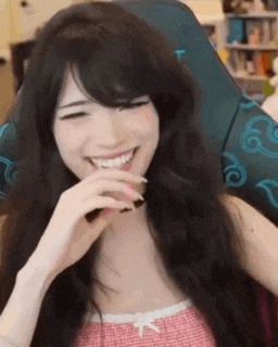 a woman is laughing while sitting in a chair .