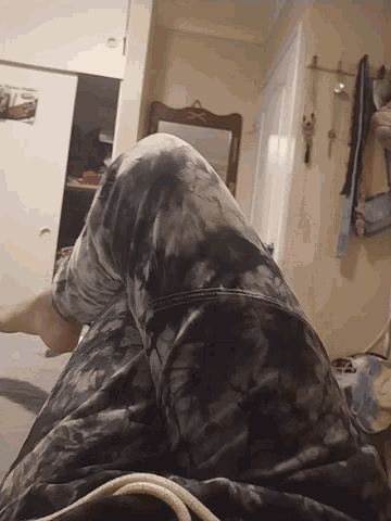 a person laying on a bed with their legs crossed in front of a mirror