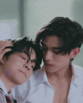 a couple of young men are laying next to each other .