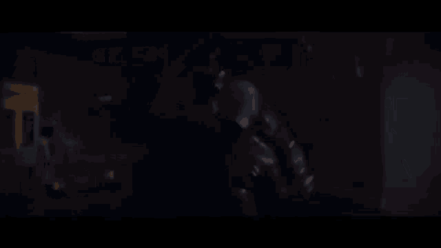 a person is standing in a dark room with a glowing object in the foreground .