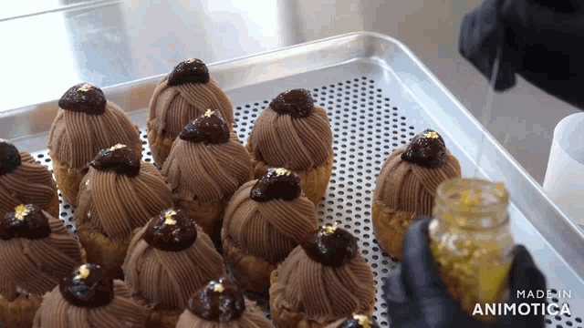 a bunch of cupcakes are on a tray with the words made in animatica in the corner